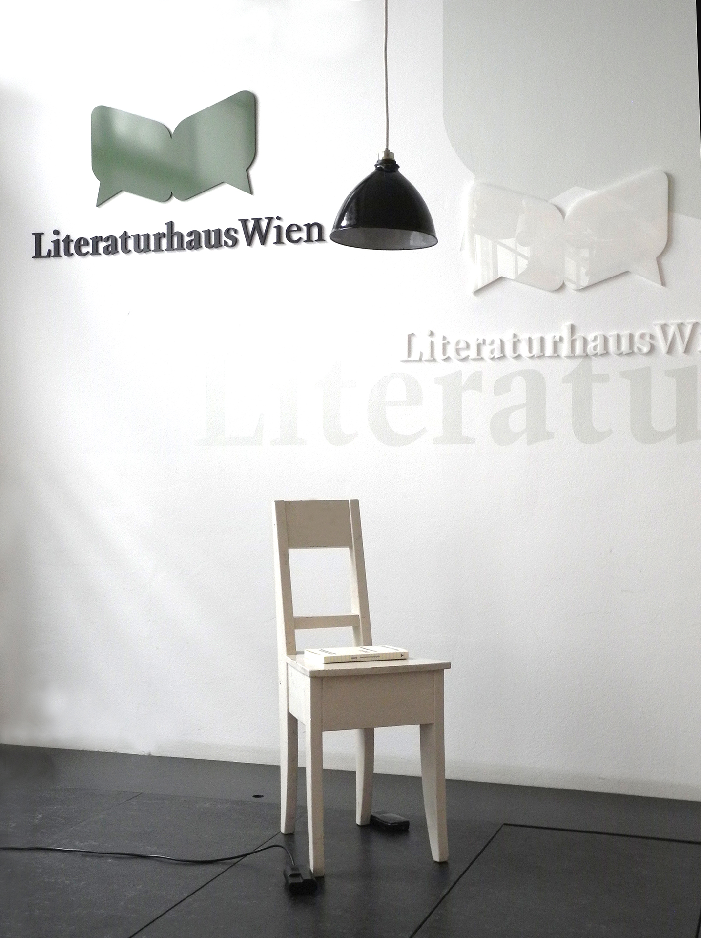 minimalistische Szene für die Lesung / Erstpräsentation von GRATE: Lampe + Sessel auf einer Bühne Autorin Hanne Römer Lesung Literaturhaus Wien